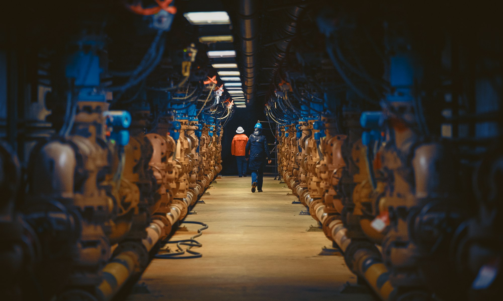 Operators walking through a water treatment pumping gallery